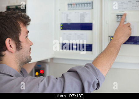 Electrician examining control panel Stock Photo