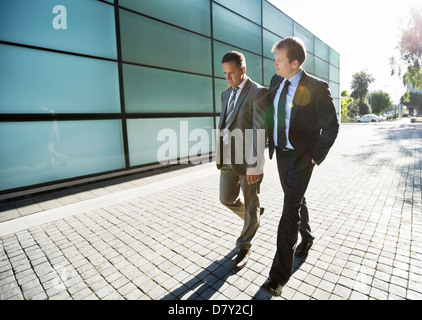 Businessmen walking on city street Stock Photo