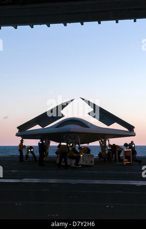 US Navy sailors move the X-47B Unmanned Combat Air System aircraft on the elevator for launch from the flight deck of the aircraft carrier USS George H.W. Bush May 14, 2013 in the Atlantic Ocean. The George H.W. Bush is the first aircraft carrier to successfully catapult launch an unmanned aircraft from its flight deck. Stock Photo