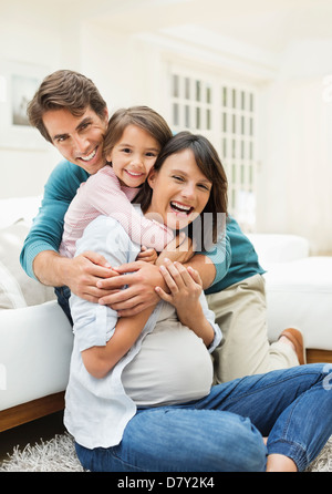 Family hugging in living room Stock Photo