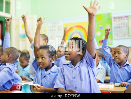 Students raising hands in class Stock Photo