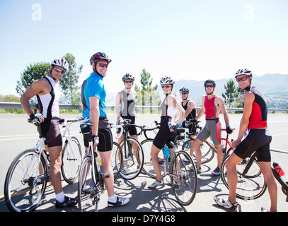Cyclists smiling together on rural road Stock Photo