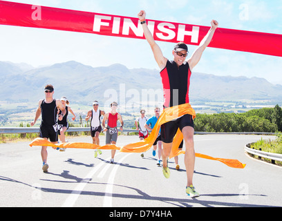 Runner crossing race finish line Stock Photo