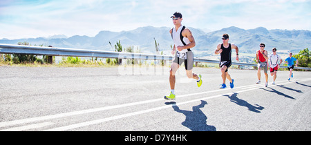 Runners in race on rural road Stock Photo