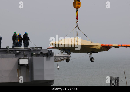 An X-47B is loaded onto flight deck of USS George H.W. Bush. Stock Photo