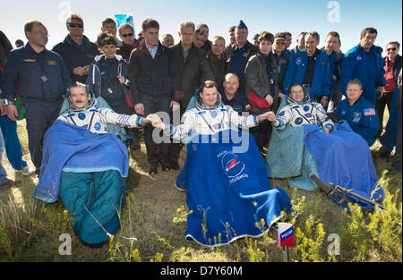 Canadian Space Agency Expedition 35 Commander Chris Hadfield, left, Russian Federal Space Agency cosmonaut Roman Romanenko, center, and NASA astronaut Tom Marshburn sit in chairs outside the Soyuz Capsule just minutes after they landed in a remote area May 14, 2013 outside the town of Dzhezkazgan, Kazakhstan.  Hadfield, Romanenko and Marshburn are returning from five months onboard the International Space Station where they served as members of the Expedition 34 and 35 crews. Stock Photo