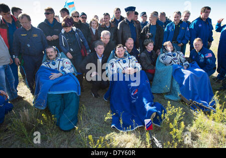 Canadian Space Agency Expedition 35 Commander Chris Hadfield, left, Russian Federal Space Agency cosmonaut Roman Romanenko, center, and NASA astronaut Tom Marshburn sit in chairs outside the Soyuz Capsule just minutes after they landed in a remote area May 14, 2013 outside the town of Dzhezkazgan, Kazakhstan.  Hadfield, Romanenko and Marshburn are returning from five months onboard the International Space Station where they served as members of the Expedition 34 and 35 crews. Stock Photo