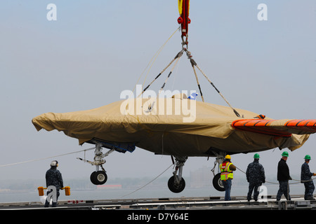 An X-47B is loaded onto flight deck of USS George H.W. Bush. Stock Photo