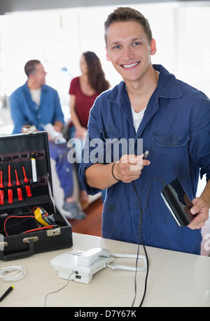 Electrician working on telephone in home Stock Photo