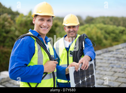 Workers smiling on roof Stock Photo