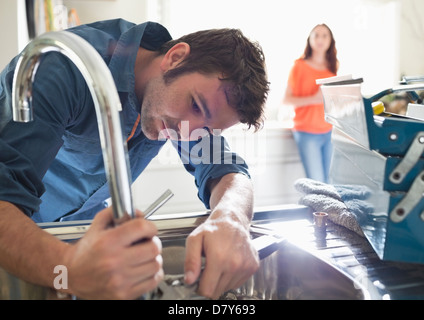 Plumber working on kitchen sink Stock Photo