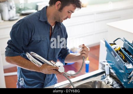 Plumber working on kitchen sink Stock Photo