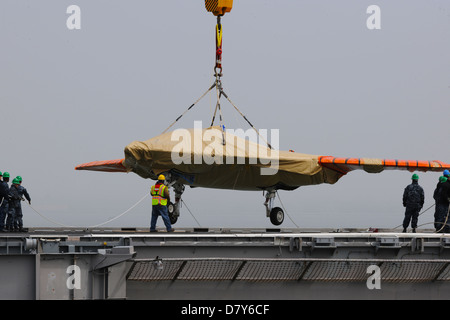 An X-47B is loaded onto flight deck of USS George H.W. Bush. Stock Photo