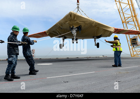 An X-47B is loaded onto flight deck aboard USS George H.W. Bush. Stock Photo