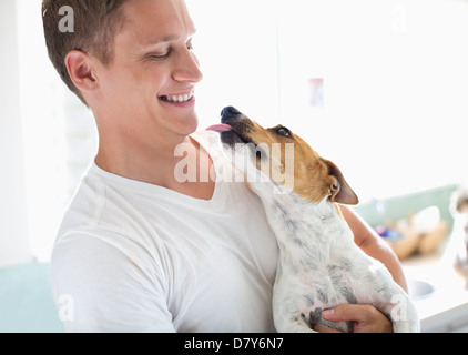 Smiling man holding dog Stock Photo