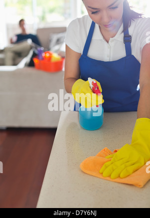 Maid cleaning kitchen counter Stock Photo