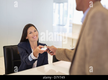 Business people exchanging cards in office Stock Photo
