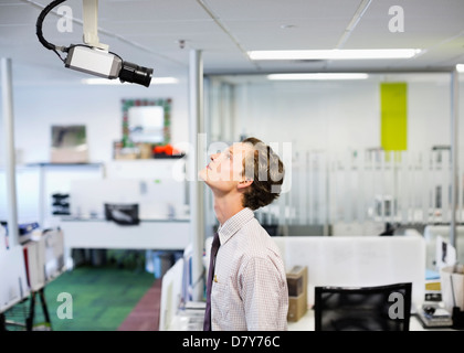 Businessman examining security camera in office Stock Photo