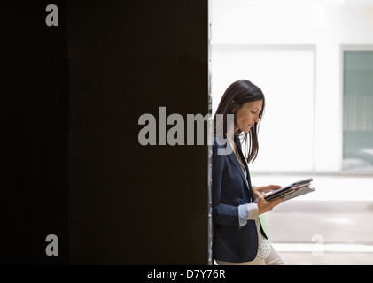 Businesswoman reading in office Stock Photo