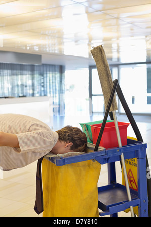 Businessman putting face in trash bag Stock Photo