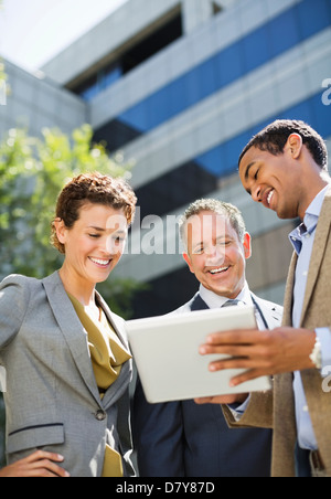 Business people using tablet computer outdoors Stock Photo