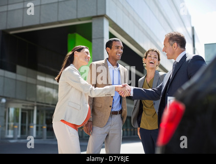 Business people shaking hands outdoors Stock Photo