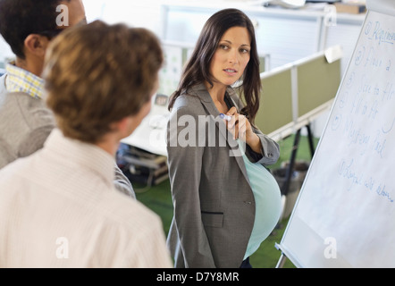 Pregnant businesswoman talking in meeting Stock Photo