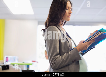Pregnant businesswoman working in office Stock Photo