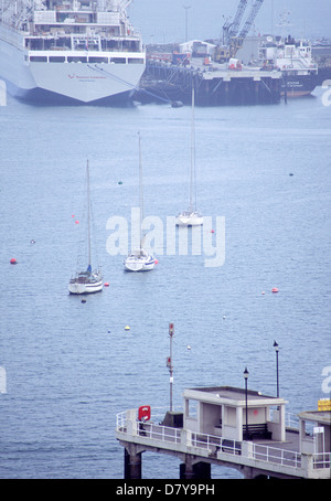 Falmouth, Cornwall, UK-March 27 2003: The pier, a line of sail boats & ferry boat in the mist on 27 March 03 at Falmouth Harbour Stock Photo