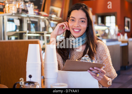 Mixed race woman working in coffee shop Stock Photo