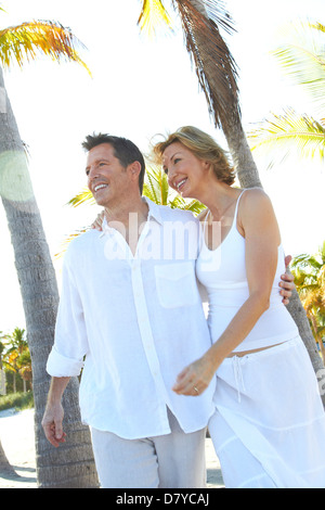 Caucasian couple walking on tropical beach Stock Photo