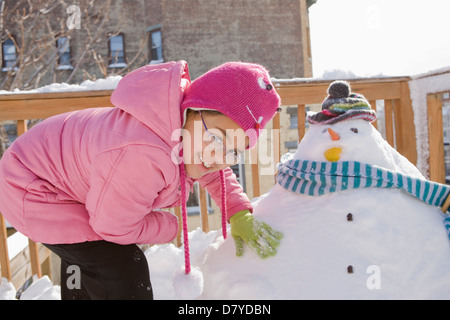 Hispanic girl making snowman Stock Photo