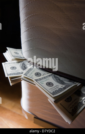 Dollar bills stuffed between mattresses Stock Photo