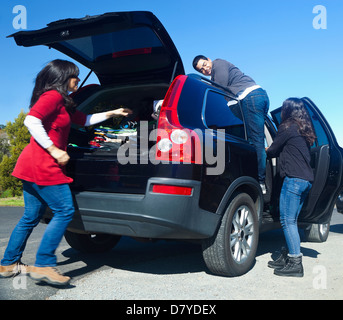 Hispanic family packing up car Stock Photo