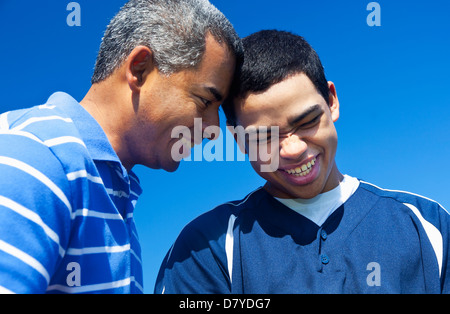 Hispanic father and son playing in park Stock Photo