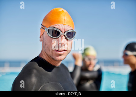 Triathletes in wetsuits wearing goggles and cap Stock Photo