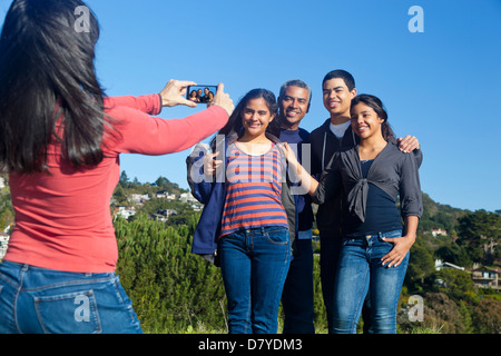 Hispanic family taking picture in park Stock Photo