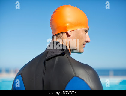 Triathlete wearing wetsuit and cap Stock Photo