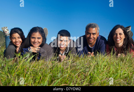 Hispanic family smiling in grass Stock Photo