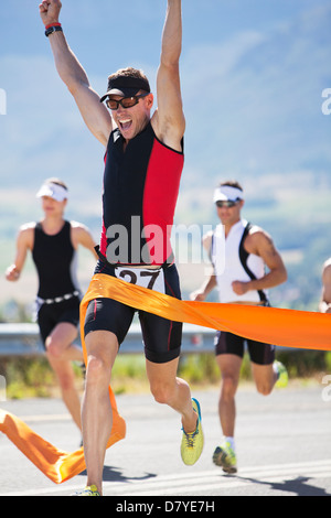 Runner crossing race finish line Stock Photo