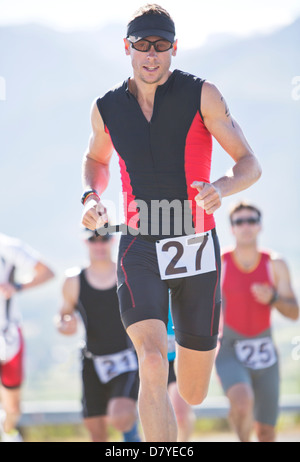 Runner in race on rural road Stock Photo