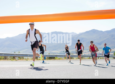 Runners crossing race finish line Stock Photo