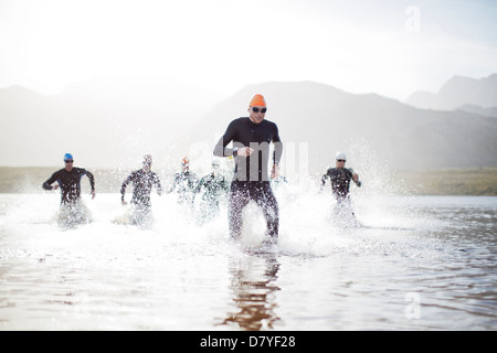 Triathletes emerging from water Stock Photo