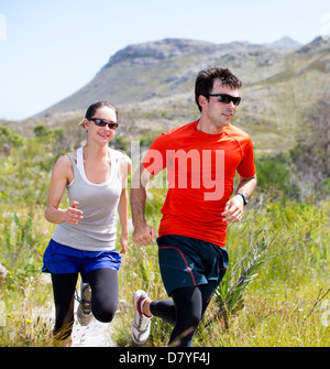 Couple running on dirt path Stock Photo