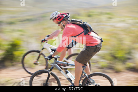 Blurred view of mountain bikers on dirt path Stock Photo