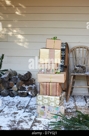 Stack of Christmas gifts on snowy patio Stock Photo