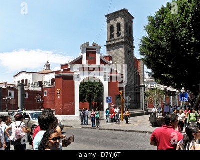 15th century church of Santo Domingo de Guzman fronts pedestrian calle Cinco de Mayo as people wait to cross traffic Puebla Stock Photo