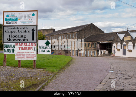 Signs & cobbled road to Greenholme Mills Trading Estate, historic mill used by variety of modern businesses - Burley-in-Wharfedale, England, GB, UK.