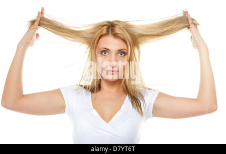 Damaged dry woman hair. Closeup portrait of woman holding hands long hair and looking unhappy. Isolated on white background. Stock Photo