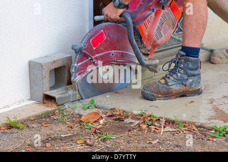workman with a wet saw for cutting concrete Stock Photo